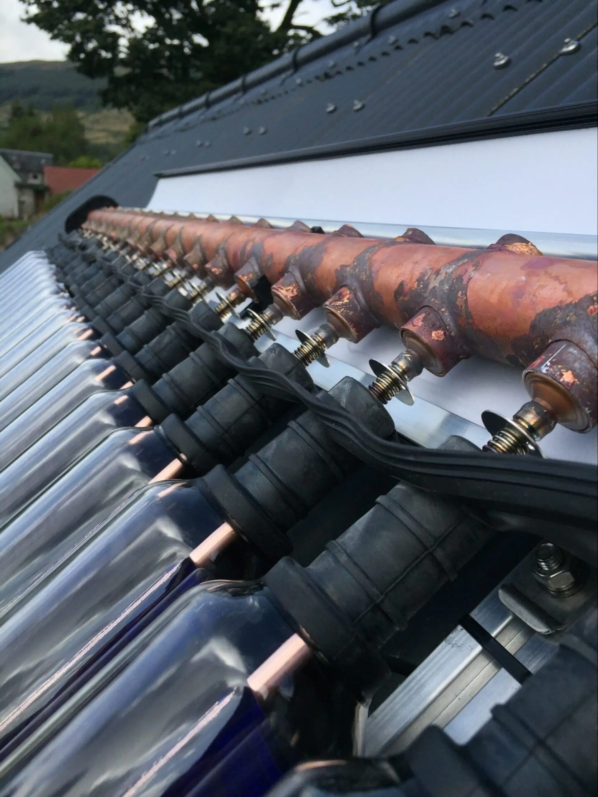 The copper manifold running along the head of an evacuated tube collector