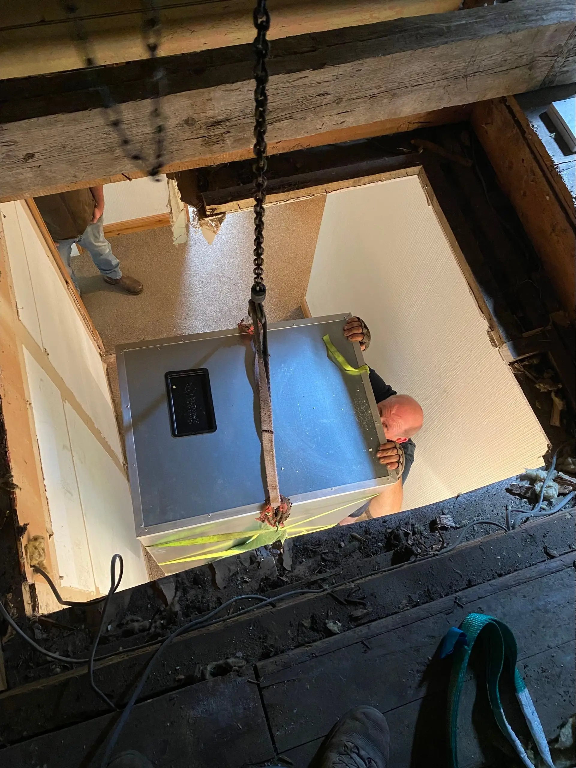 A 300 litre high‑spec store for oil, solar thermal and a boiler stove, being winched into a loft