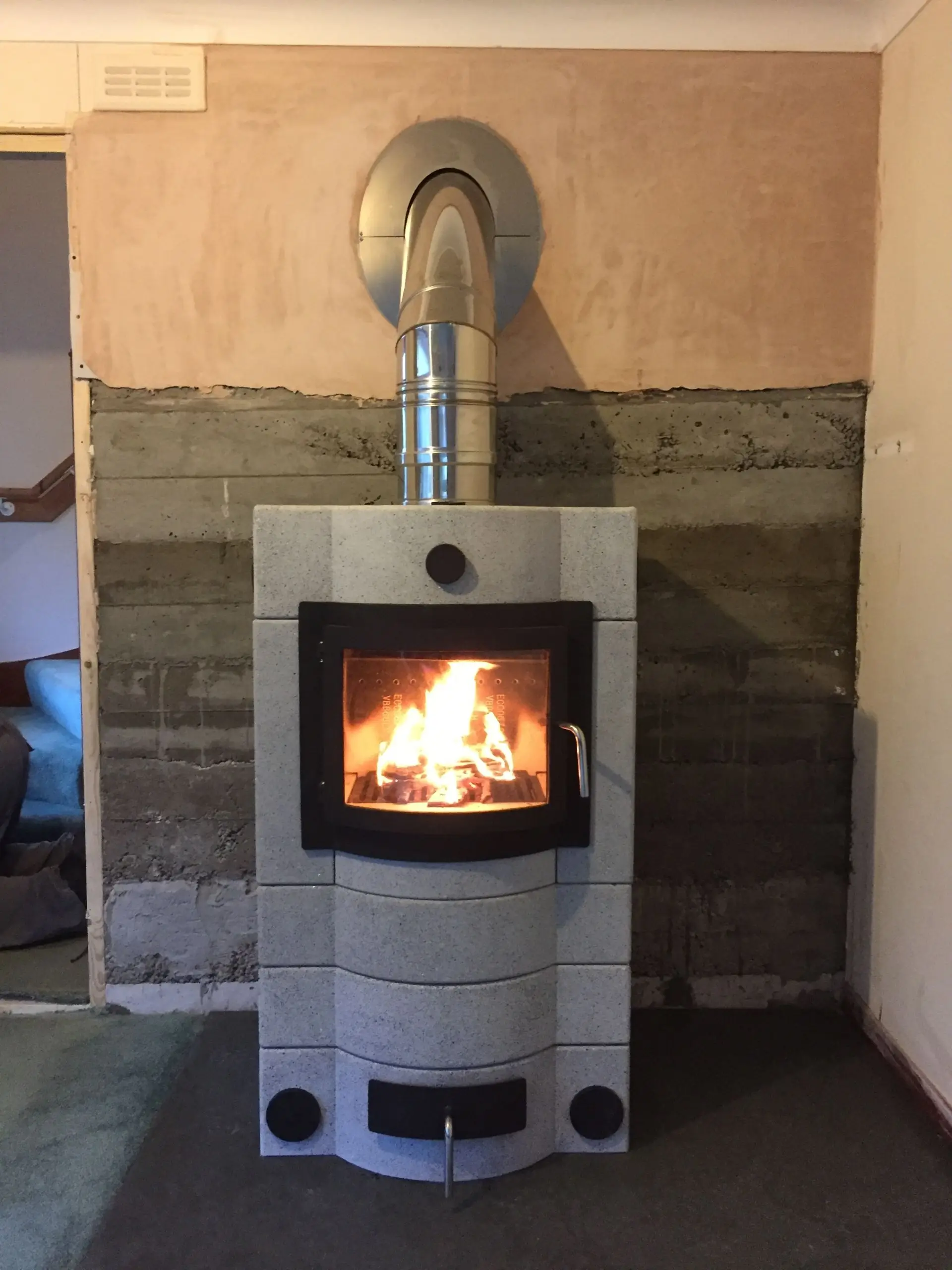 An E678 masonry stove installed in Comrie, with two additional sections raising the door height and adding mass — around 700kg